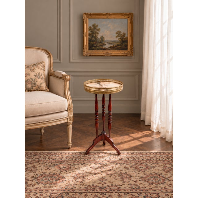 A refined vintage French gueridon side table featuring a beautifully veined marble top enclosed within a pierced brass...