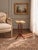 A refined vintage French gueridon side table featuring a beautifully veined marble top enclosed within a pierced brass...