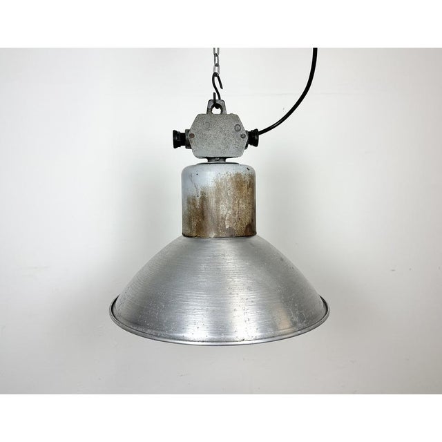 This industrial factory pendant lamp was made by Polam Wilkasy in Poland during the 1960s. It features an aluminium shade...