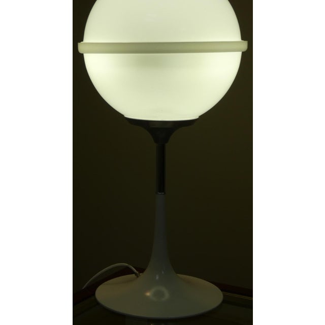 This table lamp perfectly embodies the Space Age style of the late 1960s. The spherical shade is made of acrylic glass and...