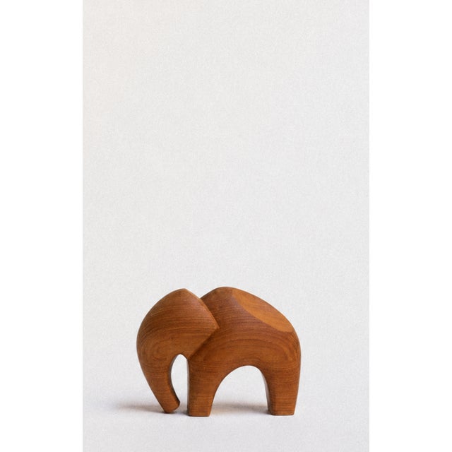 Hand-carved from solid wood, this large elephant sculpture is defined by its soft, flowing form and beautifully figured...