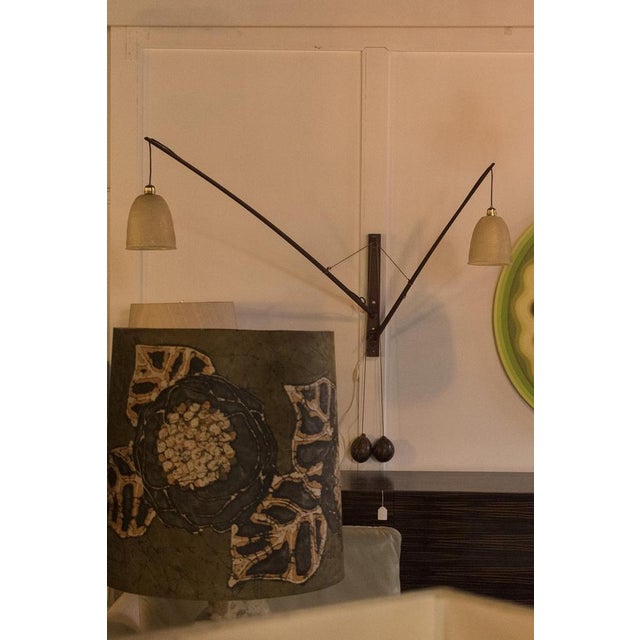 Extraordinary adjustable wall lamp made from teak with coconut weights. This lamp is adjustable with the coconut weights...