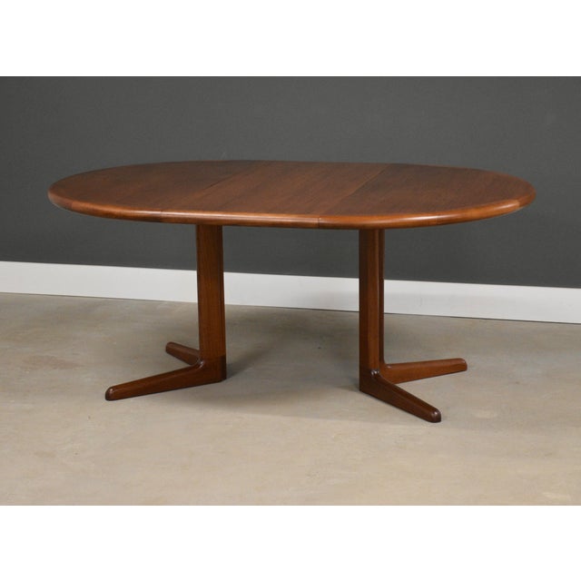 A mid century modern teak round dining table with two leaves that extend it fully to 84.5” to make it oval. Minor bubbling...