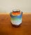 Marked Made in Japan. A vibrant miniature vase adorned with a richly colored, hand-painted figure framed by ornate...