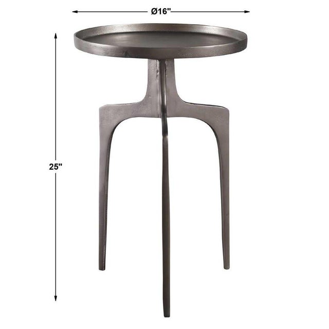 Providing an organic global feel, this cast aluminum accent table features a shapely curved base and round top, finished...