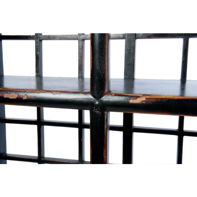 This 3-shelf, 5-drawer display cabinet is finished with an antiqued black paint with exposed wood details, inset side...