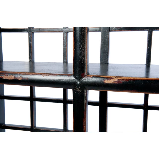 This three shelf, five drawer display cabinet is finished with an antiqued black paint with exposed wood details, inset...