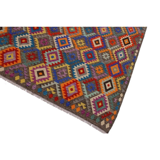 Add a touch of elegance to your home with this casual chic hand woven Tribal Kilim wool rug. Constructed on a loom by...