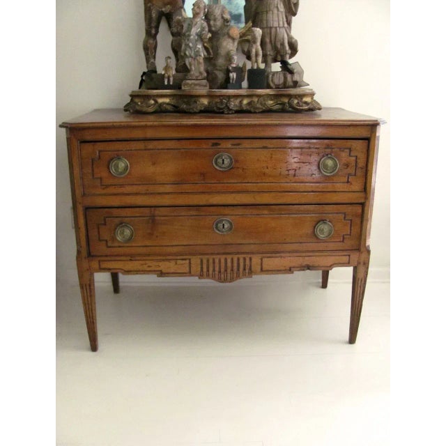 Italian two drawer fruitwood commode with fluted square tapering legs. Moulded top, carved apron. Measures 45" by 23" by...