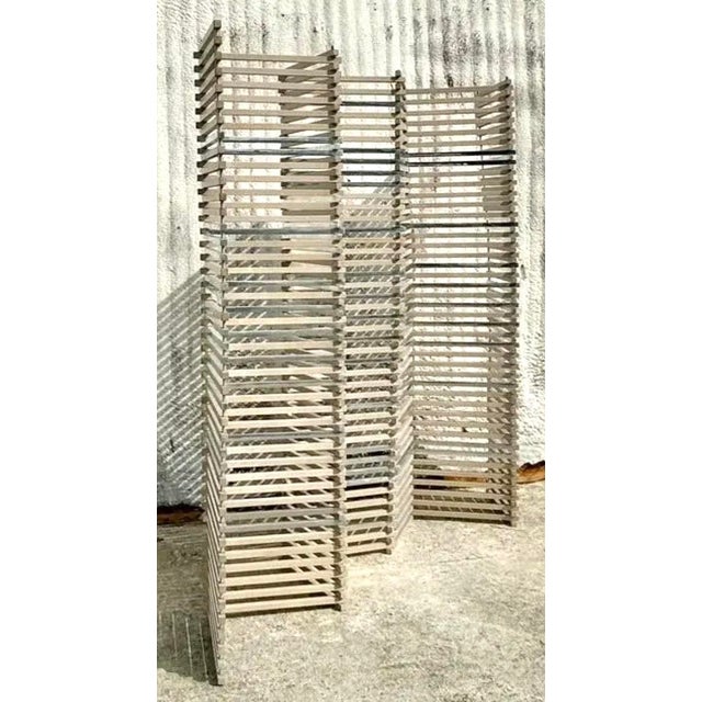 Add a bold architectural statement to your space with this vintage boho stacked wood and chrome folding screen. This...