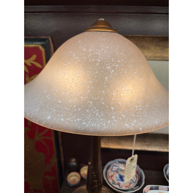 gorgeous art nouveau lamp with glass shade and floral carved design on base.