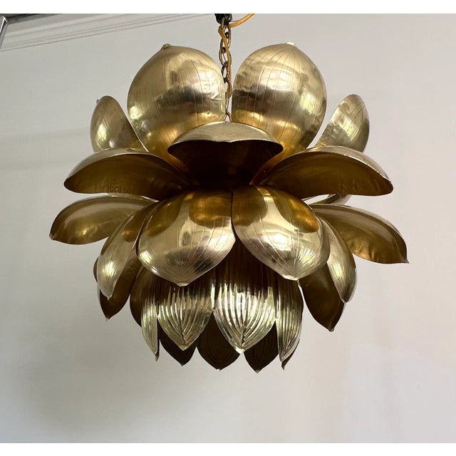 Single large brass pendant light in the shape of an open lotus flower by Feldman. Petals feature an etched design. More...