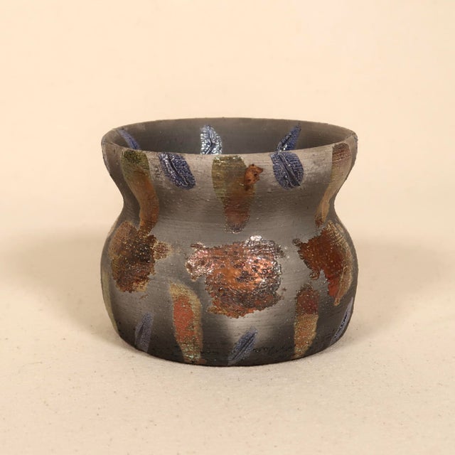 A striking signed studio pottery vase featuring a compact, sculptural form with a softly cinched waist and flared rim. The...