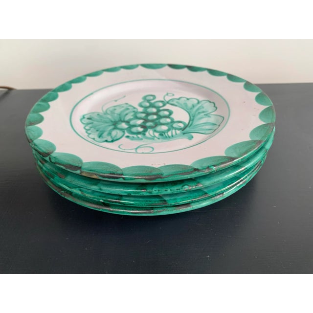 A set of 4 hand made and decorated Italian pottery plates in a greenish turquoise on a lightly glazed background of white....