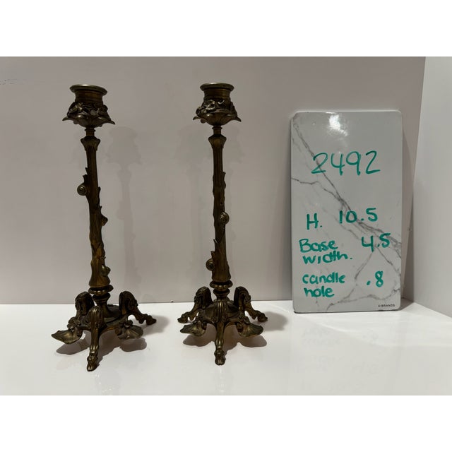 Decorative pair of cast brass candlesticks featuring naturalistic branch-form stems, floral candle cups, shell ornament...