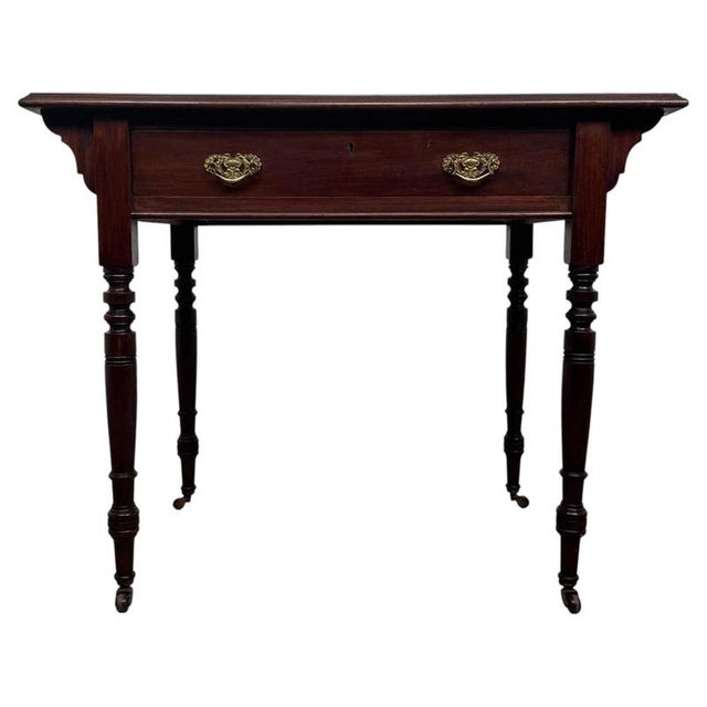 An elegant early 20th-century English writing table, finely crafted from mahogany and distinguished by its green leather...