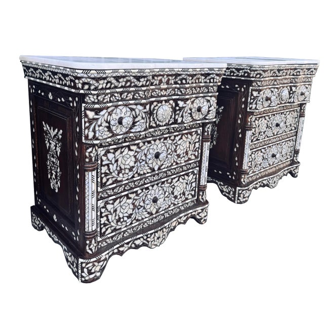 An elegant pair of vintage mother-of-pearl inlay nightstands, dating from circa 1980–1990, showcasing the enduring...