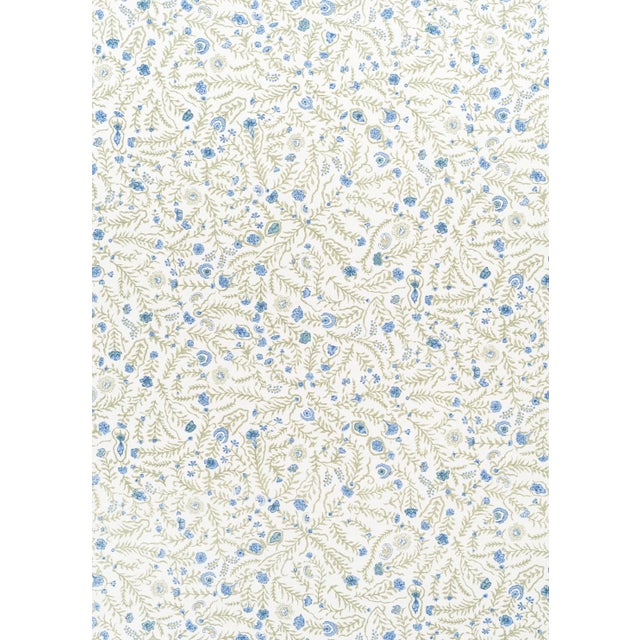 Delicate botanical fabric featuring a trailing vine and floral motif. Printed on oyster linen with tones of blue and...