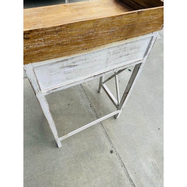 This is a vintage-style wooden washstand or side table with a distressed, shabby-chic finish. It has a single drawer with...