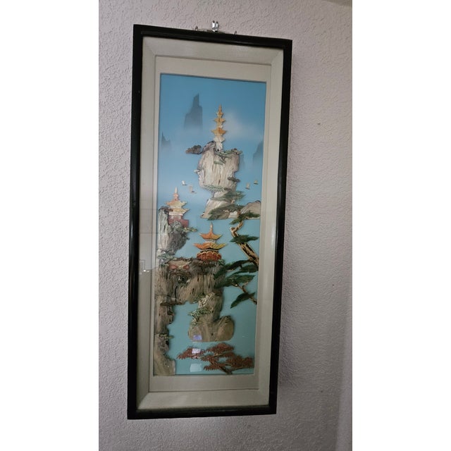 Beautiful art pieces featuring intricate designs made from shells, arranged in a three-dimensional shadow box format.