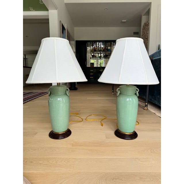 Pair of Frederick Cooper table lamps featuring elegant celadon crackle-glazed ceramic urn forms adorned with decorative...
