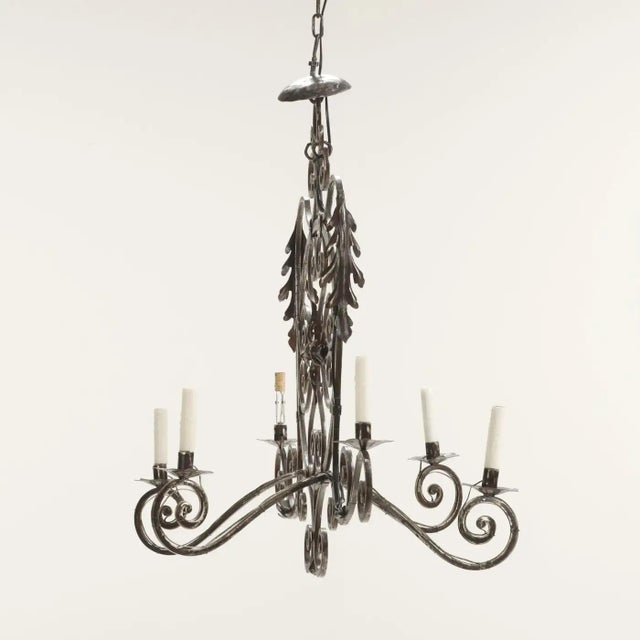 A striking 19th-century French Provincial chandelier, hand-forged from decorative steel with a beautifully aged patina....
