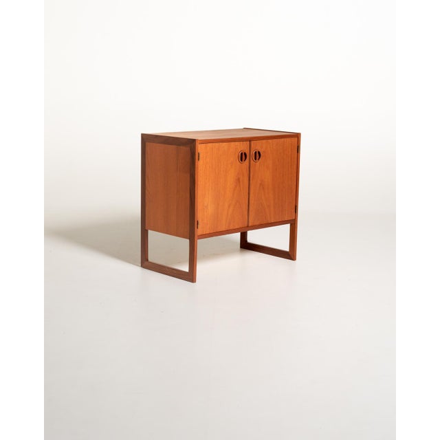 The "Domino" cabinet designed by Arne Wahl Iversen in the early 1960s. Made of teak, it features two doors with...