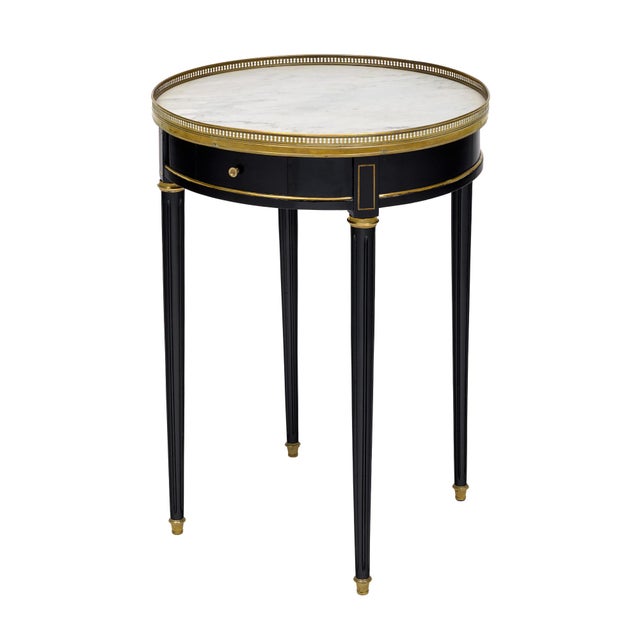 An elegant Louis XVI style bouillotte table of refined neoclassical proportions, crafted in ebonized wood and accented...