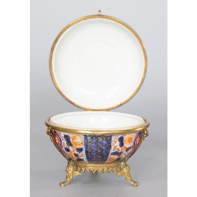 A fine and rare lidded and hinged Imari bowl or jewelry box with ormolu fittings, set atop three ornamented feet. Perfect...