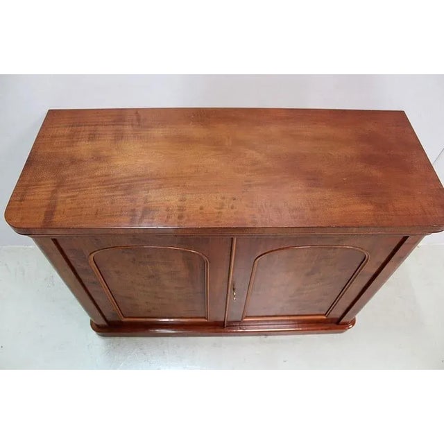 Small Victorian sideboard in solid Mahogany and Cuban Mahogany veneer. Its top is molded in a belt and rounded in its...