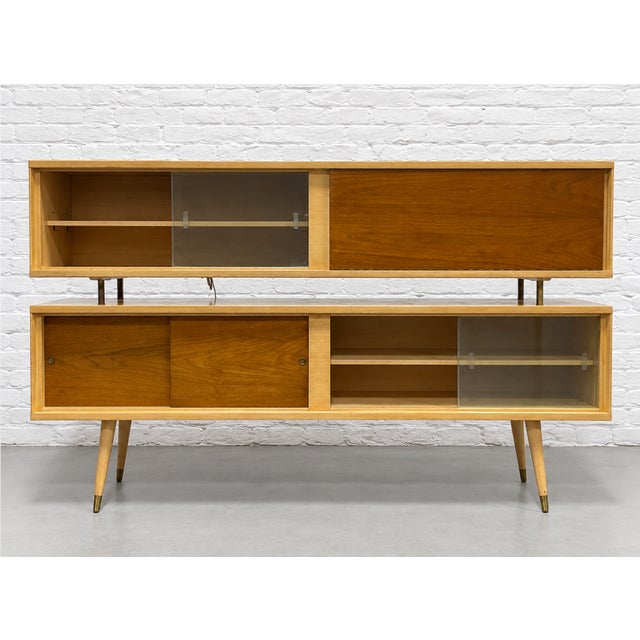 Mid Century Modern two part credenza featuring long splayed legs, a drop down bar with lighting and loads of storage...