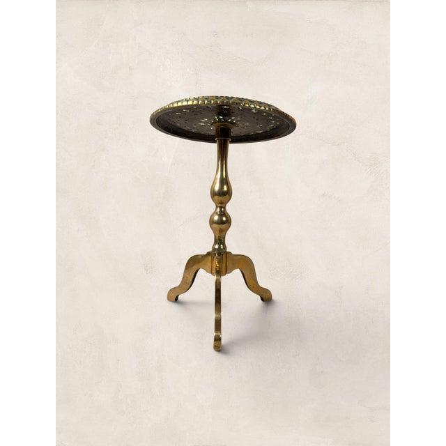 A brass kettle stand with a pie-crust rim, turned pedestal, and cabriole tripod legs. This is Georgian craftsmanship at...