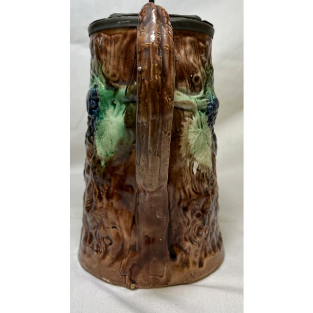 English Antique 19th Century Majolica Pitcher /Jug With Pewter Top Decorated With a Vibrant Grape & Vine Pattern Against a Brown Tree-Like Textured Background For Sale - Image 3 of 11