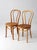 Pair of vintage ZPM Radomsko bentwood café chairs made in Romania, featuring flowing bentwood frames, looping backs, and...