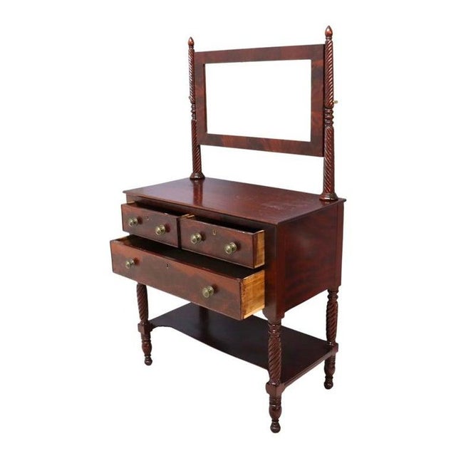 An antique Sheraton style dressing table, crafted from carved mahogany, dating to approximately 1830. This distinguished...