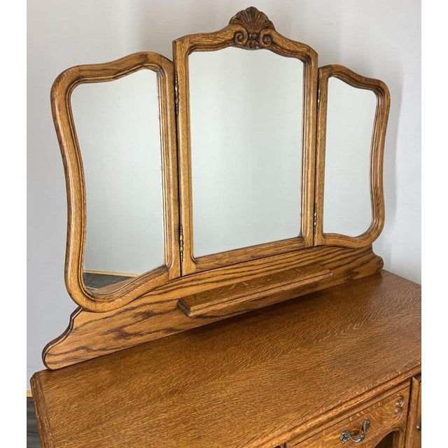 A beautifully crafted Vintage French Louis dressing table in oak, showcasing elegant carved detailing, cabriole legs and a...