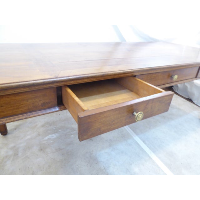 This solid walnut dining table has an inlay design in the center, three drawers and pullout slides in either end.