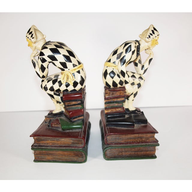A pair of French Art Deco Harlequin/clown bookend/statues. Very detailed. Figures are sitting on two books with their...