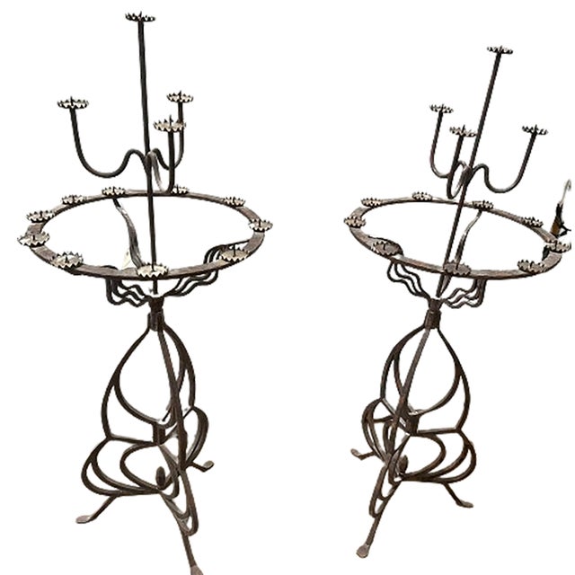 A handsome pair of antique gothic style pedestal candelabra torcheres. Made of wrought iron. Contains 13 candle holders at...
