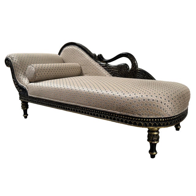 A dramatic vintage récamier (fainting couch) in the French Empire style with a black lacquered frame hand-carved with a...