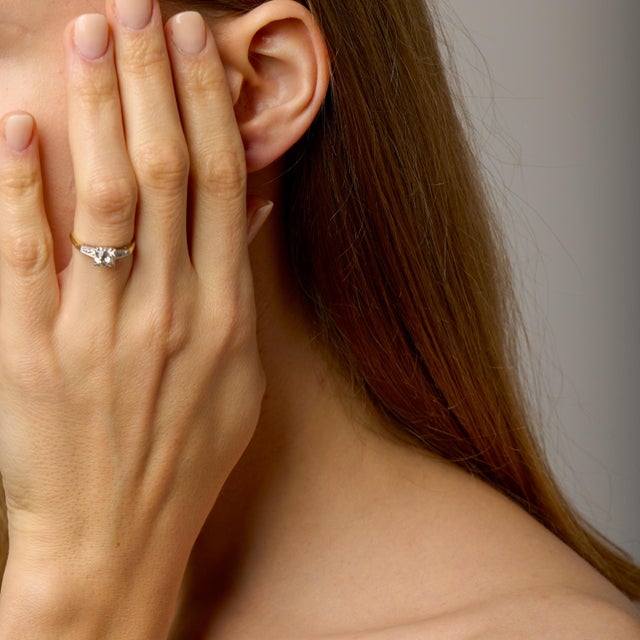 This Retro engagement ring is a beautiful expression of 1940s design, blending warmth, contrast, and timeless...