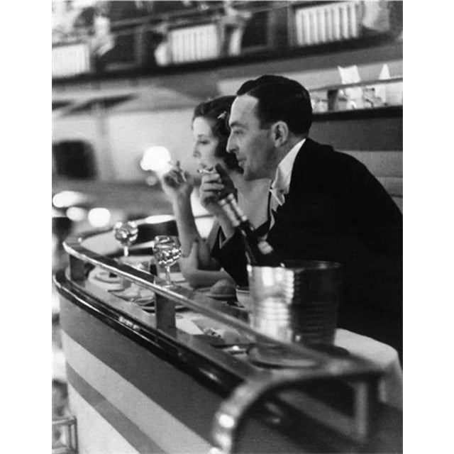 A couple dining out at an elegant hotel in New York is caught momentarily distracted by the floor show. 16" x 20" print...