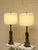 A striking pair of Brutalist-inspired table lamps featuring sculptural steel bases with geometric cutout details and an...