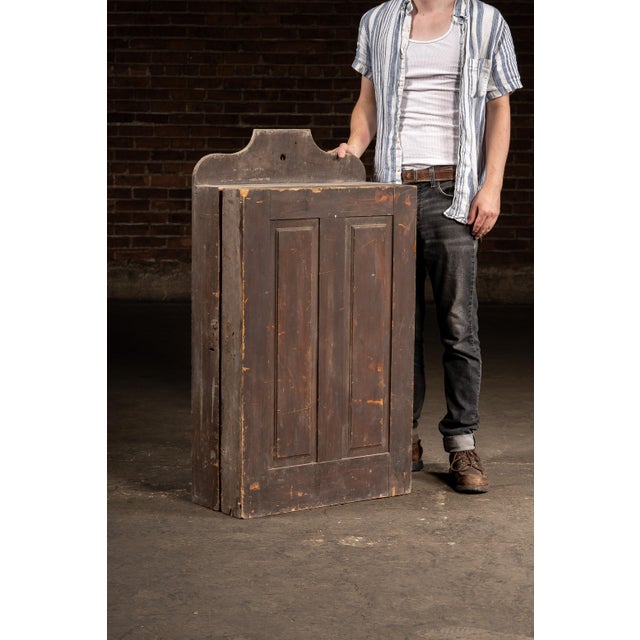 An early example of wall-mount cabinet, likely used to hang various tools. The cabinet features a swing-open door and...