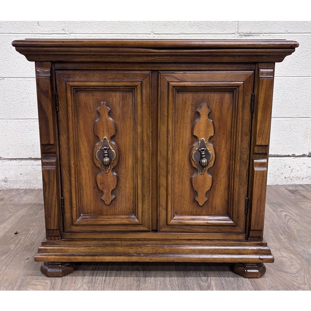 This is a handsome vintage Mediterranean/Spanish Revival style nightstand or end cabinet featuring a warm walnut-tone...