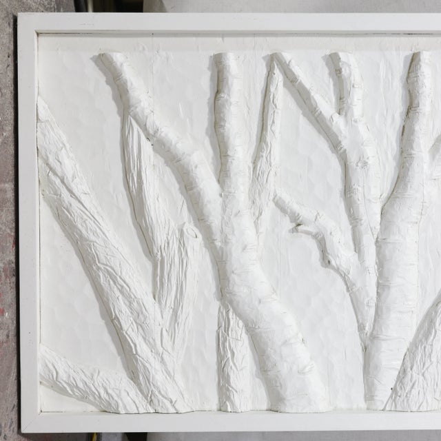 This piece of abstract wall art features a striking textured relief design suggestive of natural forms of branches....