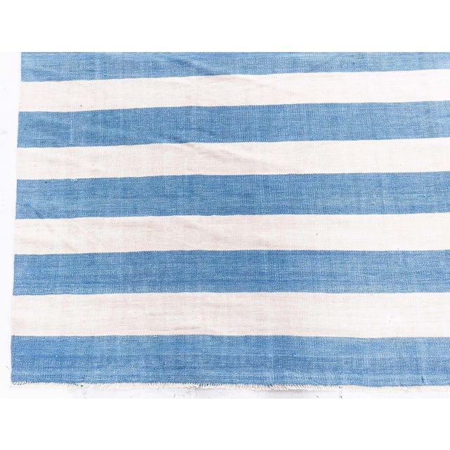 This vintage Indian Dhurrie rug, woven circa 1955, exudes a breezy, coastal elegance with its classic striped motif....