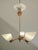Swedish designer three-arm chandelier from the 1950s, executed in brass and copper with opaline glass shades. The fixture...