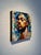 This mixed media piece features a close-up portrait of a contemplative figure, their eyes closed in serene introspection....