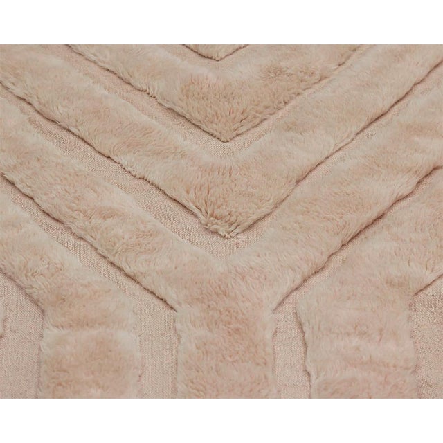 Soft chevron lines converge gently across a warm apricot cream field, giving this rug a quiet sense of movement without a...
